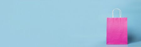 pink bag on a blue background. Shopping package. Concept of holidays, shopping, sale, discounts. Banner.の写真素材
