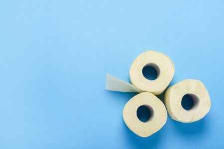 toilet paper rolls on a blue background. Flat lay, top view. Hygiene concept, deficiency,...