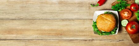 Vegetables on a cutting board on a wooden background. Products for cooking. Copy space, flat, lay. Banner.の写真素材