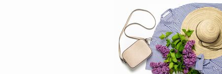 Women's summer hat, dress, bag and twigs of lilac on a white background. Copy space, flat, lay. Bannerの写真素材