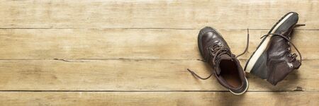 Hiking boots on a wooden background. The concept of hiking, tourism, camp, mountains, forest....