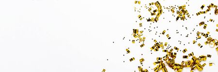 Golden confetti on a white background. The concept of a holiday, party, birthday, decoration. Banner Flat lay, top view.の写真素材