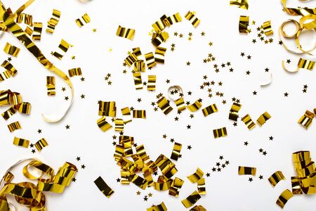 Golden confetti on a white background. The concept of a holiday, party, birthday, decoration. Banner Flat lay, top view.の写真素材