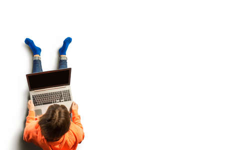 Young woman works, holds a laptop on her lap. Top view, flat lay.