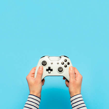 Hands holding a gamepad on a blue background. Banner. Concept games, video games.