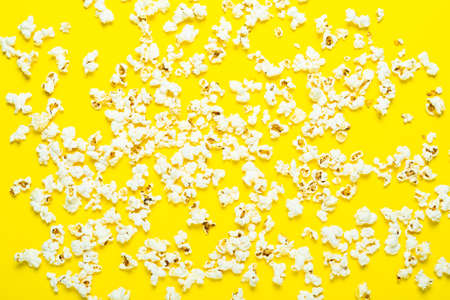 Popcorn scattered on a yellow background. Concept series, film, sports. Banner. Flat lay, top view.の写真素材