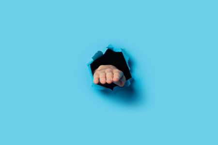 Outstretched female hand, palm down on a blue background. Banner.の写真素材