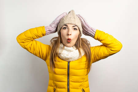 Young woman in a hat and mittens caps on a light background. Winter concept, winter fashion, winter...