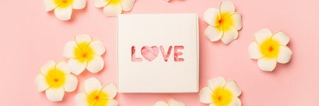 Gift box and flowers on a pastel pink background. Composition Valentine's Day. Flat lay, top view. Banner.の写真素材