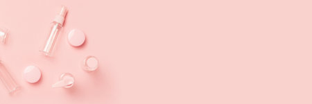 Empty tubes for cosmetics on a pastel pink background. Flat lay, top view. Banner.の写真素材