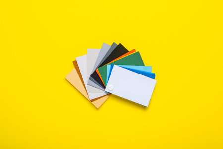 Color palette of paints on a yellow background. Top view, flat lay. Banner.