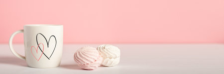 Mug with hearts and sweets on a pink background. Valentine's Day concept. Banner.の写真素材