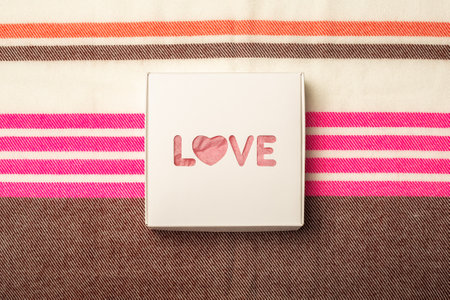 Gift box on the background of a multicolored fabric texture. Composition Valentine's Day. Banner....