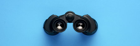 Binoculars on a light blue background. Banner. Flat lay, top view.の写真素材