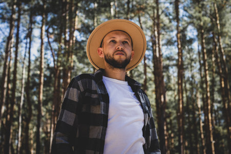 Man tourist in hat and plaid shirt in the woods.の写真素材