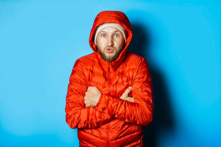 Frozen Man in a hat and a red jacket on a blue background.の写真素材