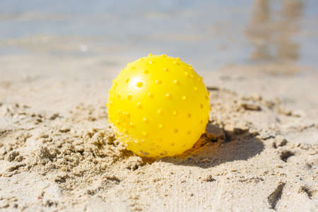 yellow ball on the sand, on the beach, children's games, travel, vacationの写真素材