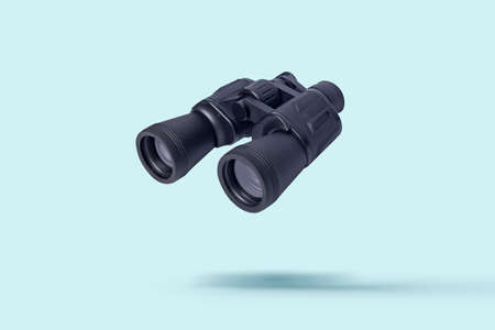 Flying binoculars on a light background. Binoculars are flying. Levitation.