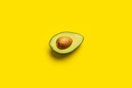 fresh ripe slice, half an avocado on a bright yellow background. Top view, flat lay.の写真素材