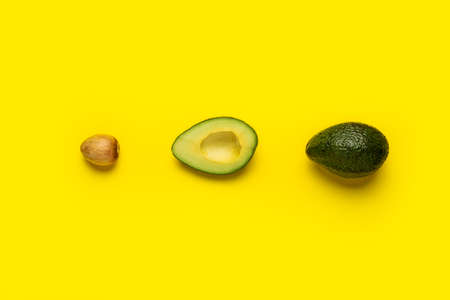 bone, half and whole avocado on a bright yellow background. Top view, flat lay.の写真素材