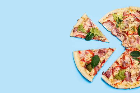 cut pizza fresh hot on a blue background. Top view, flat lay.の写真素材