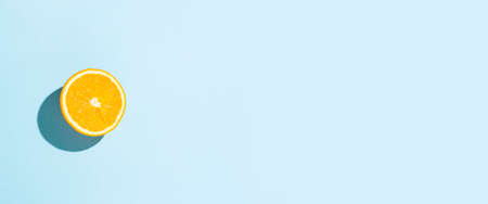 orange cut on a blue background. Top view, flat lay. Banner.の写真素材