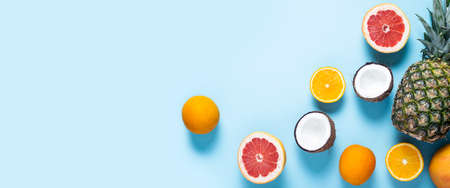 exotic fruits on a blue background. Pineapple, coconut, orange, grapefruit. Top view, flat lay....