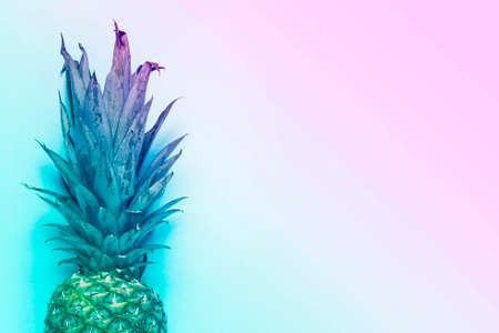 whole ripe pineapple on a blue background. Added color gradient. Top view, flat lay.の写真素材
