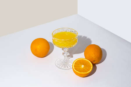 glass with fresh juice and oranges on the table on a light background. Top view, flat lay.の写真素材