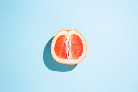 cut half of a grapefruit on a blue background. Top view, flat lay.の写真素材