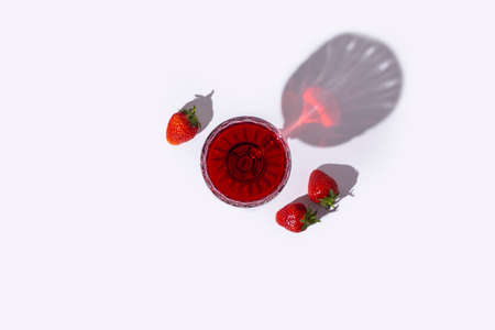 glass with red wine and strawberries on the table on a light background. Top view, flat lay.の写真素材
