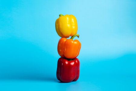 Three fresh bright sweet peppers on a blue background. Top view, flat lay.の写真素材