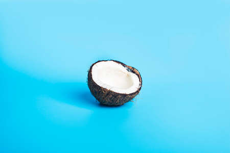 Coconut white. One half opened coconut on a blue background.の写真素材