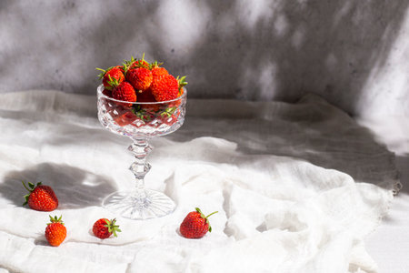Fresh red strawberries in a glass on a table on a concrete background.の写真素材