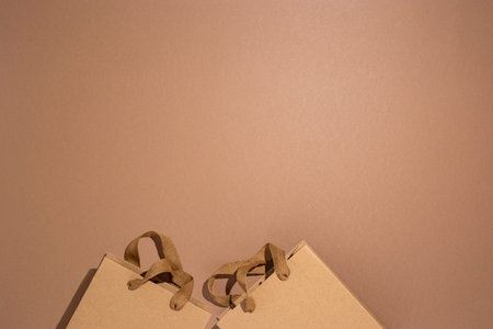 Packaging bags for gifts, craft brown on a brown cardboard background. Top view, flat lay.の写真素材