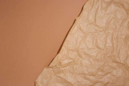 Crumpled craft paper on a brown cardboard background.の写真素材