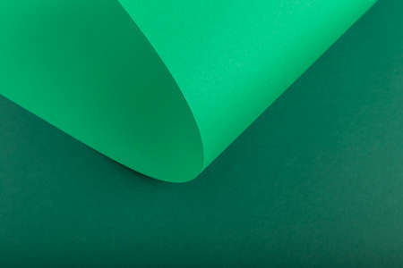 Design background of folded curl from green cardboard. Top view, flat lay.