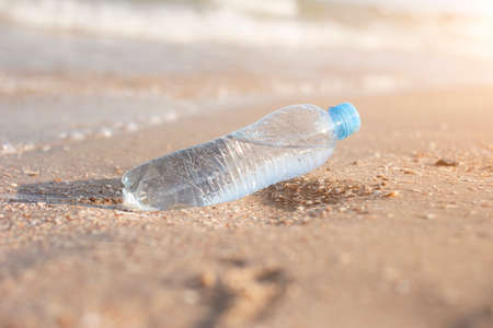 Plastic bottle with water on the background of a sandy beach on a sunny day.の写真素材