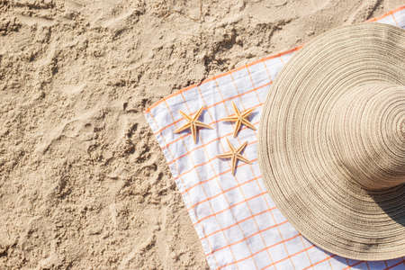 Gold starfish, hat on the sandy beach. Top view, flat lay.の写真素材