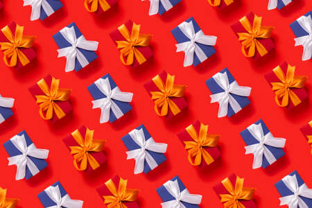 Lots of Christmas gift boxes on a red background. Top view, flat lay.の写真素材