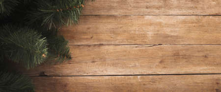 Wooden background with branches of a Christmas tree. Concept for Christmas and New Year. Banner. Flat lay, top view.の写真素材