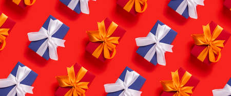 Lots of Christmas gift boxes on a red background. Top view, flat lay. Banner.の写真素材