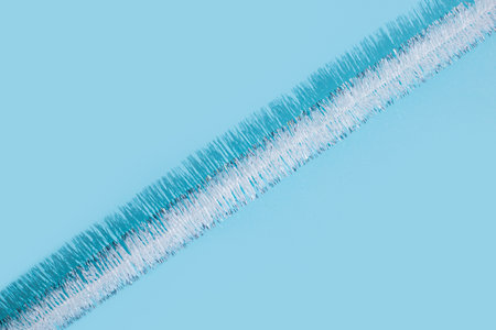 Christmas New Year tinsel on a blue background. Top view, flat lay.