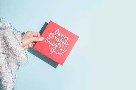 Hand holds a congratulatory envelope on a blue background. Hard shadows.の写真素材