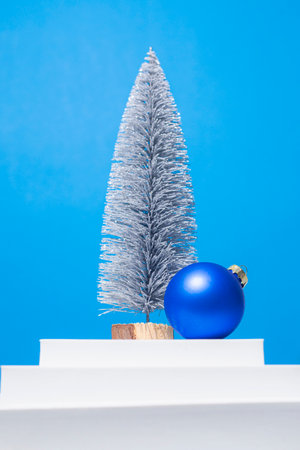 Christmas tree, decorative ball on a white podium on a blue background.の写真素材