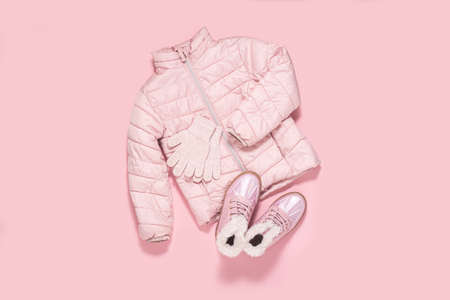Jacket, gloves and shoes for children for a girl on a pink background. Top view, flat layの写真素材