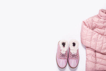 Kids jacket and boots for a girl on a white background. Top view, flat lay. Banner.の写真素材