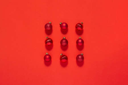 Beautiful red small decorative balls are scattered on a red background. Top view, flat layの写真素材