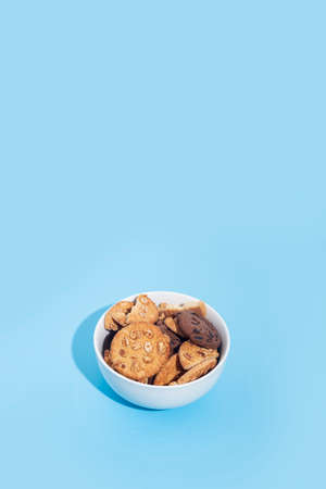 Cookies in a white bowl, blank space for text on a light blue background
