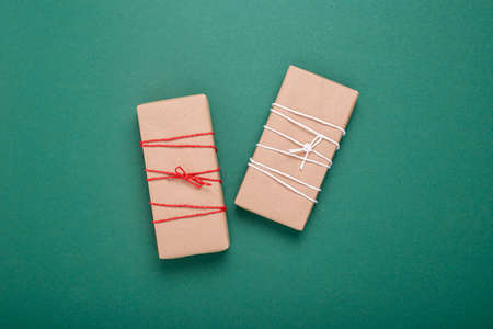 Two gift wrappers on a dark green background. Top view, flat lay